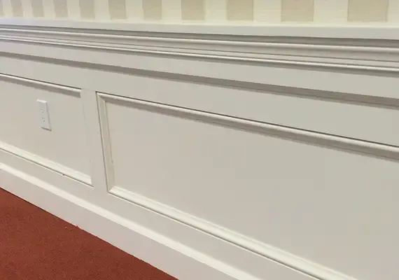 White raised-panel wainscoting with chair rail above a red carpet