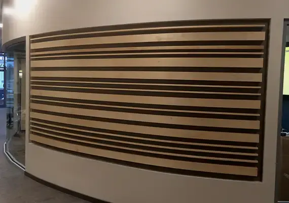 Curved wall with horizontal light and dark wood slat paneling