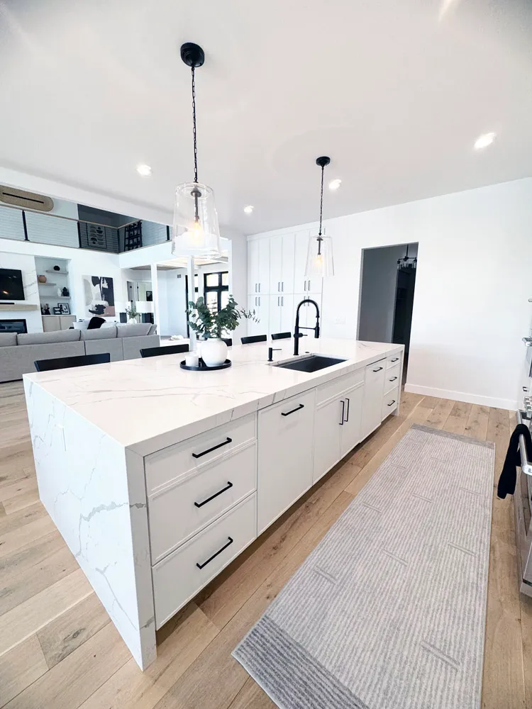 White island with black hardware and waterfall marble-look top, open to the living room