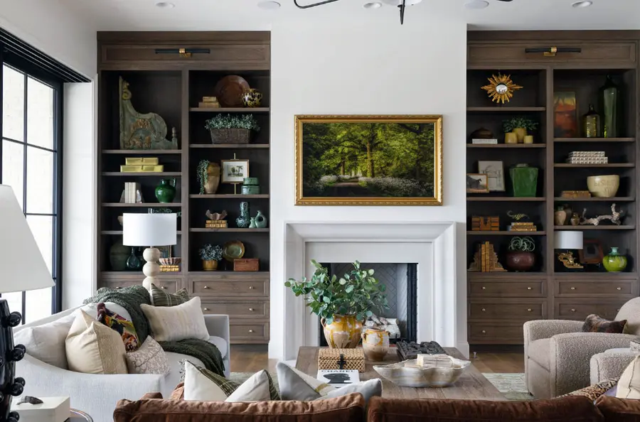 Living room with dark wood built-in bookshelves flanking a white fireplace