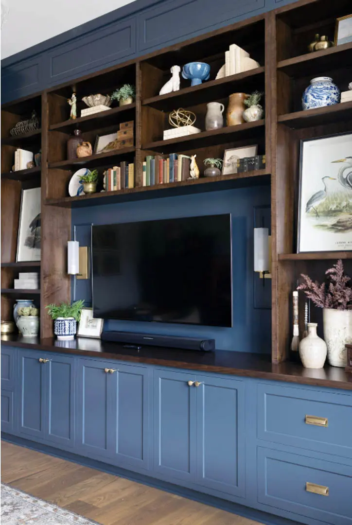 Blue built-in media cabinet with wood bookshelves surrounding a wall-mounted TV