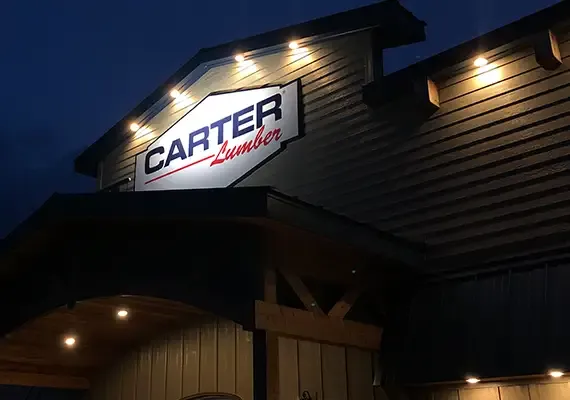 Illuminated Carter Lumber sign on a store building at night