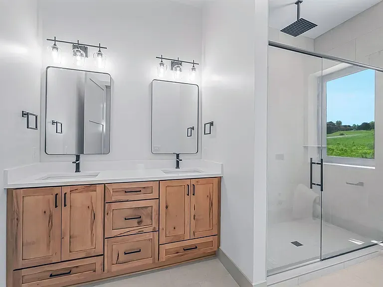 Bathroom with a rustic wood double vanity, black fixtures, and glass walk-in shower