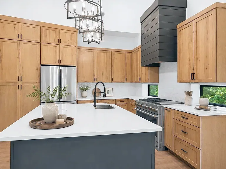 Warm wood shaker cabinets, black shiplap range hood, and a dark island with white top