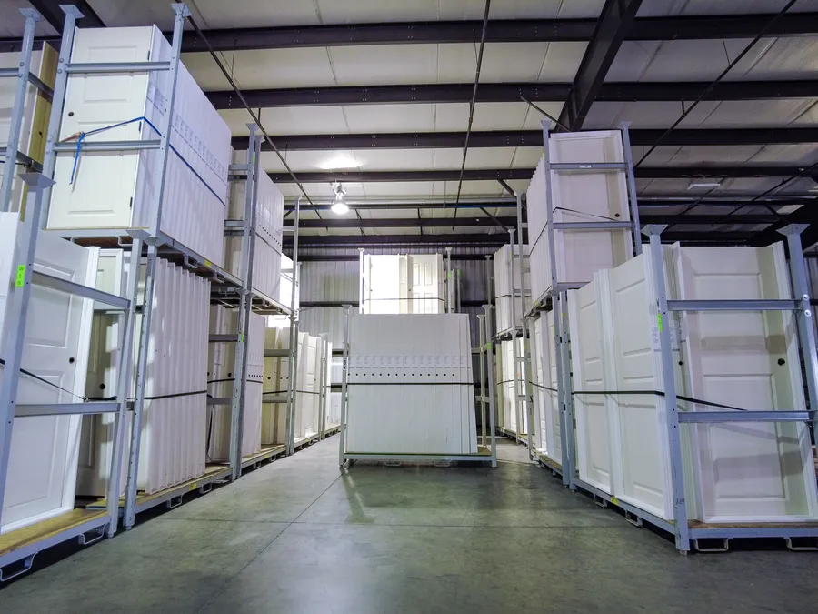 Racks of white prehung interior doors stored in a warehouse