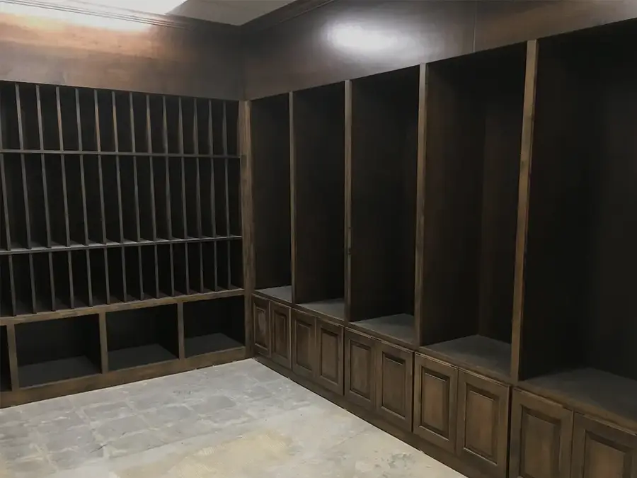 Room of built-in dark wood cubbies, open lockers and raised-panel lower cabinets