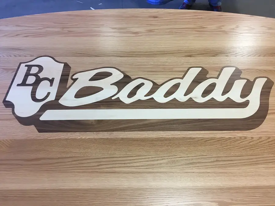 Wood table top inlaid with the BC Boddy logo