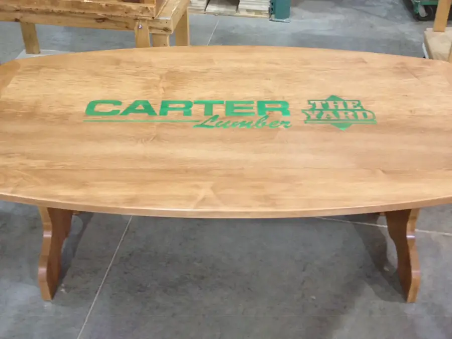 Wood conference table inlaid with Carter Lumber and The Yard logos
