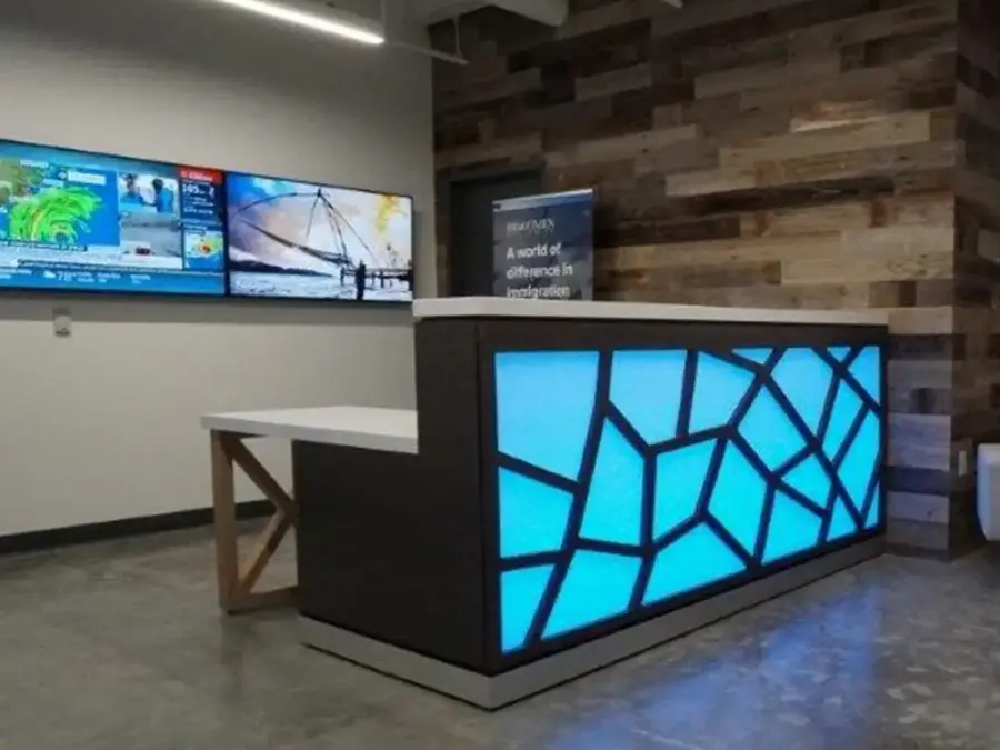 Reception desk with a backlit blue geometric front panel and white top