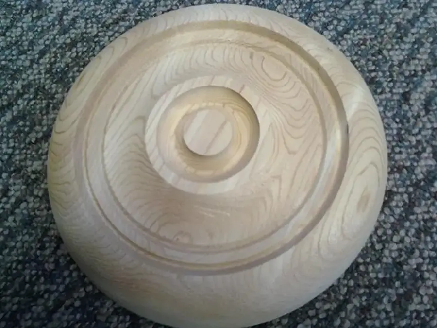 Round turned wood rosette with concentric grooves