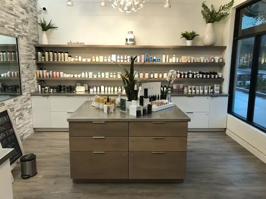 Retail display island and shelving with wood-grain drawers in a skincare shop