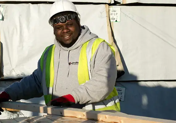 Smiling Kempsville yard worker in a hard hat and safety vest