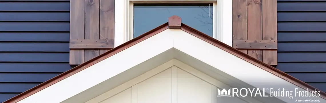 Navy lap siding with wood board-and-batten shutters and a white gable trim