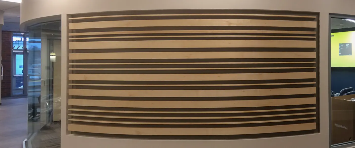 Curved wall with horizontal light and dark wood slat paneling