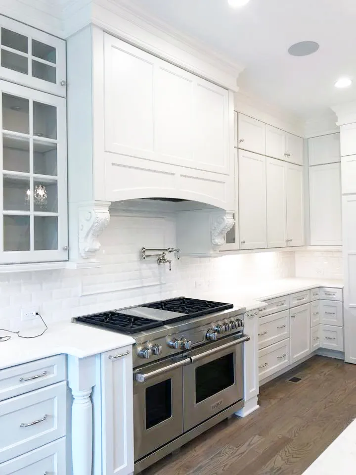 White cabinet range wall with corbel hood, pot filler and dual-fuel range