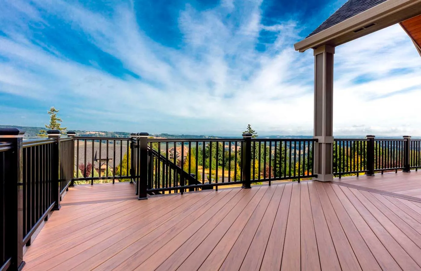 Composite deck with black metal railing overlooking a wide valley view