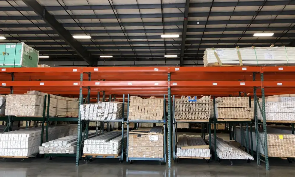 Warehouse pallet racks loaded with bundled white moulding and trim