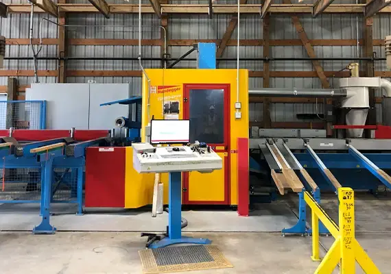 Hundegger beam-cutting machine with control station and conveyors in a plant