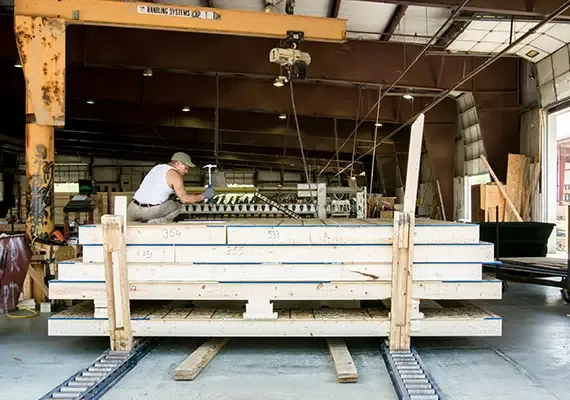 Worker building a wall panel on an assembly line in a component plant