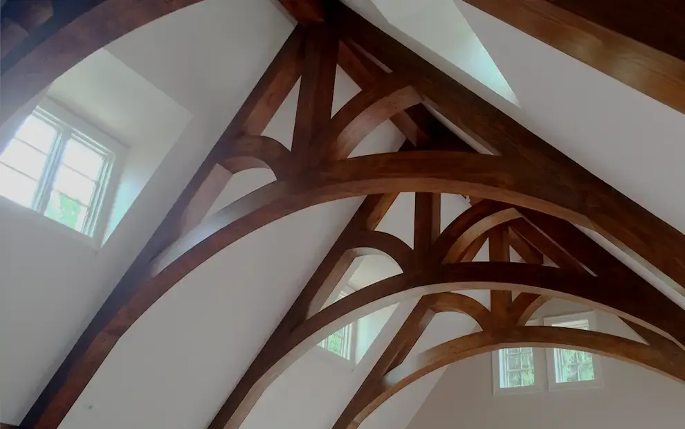 Vaulted ceiling with curved stained timber trusses and arched braces