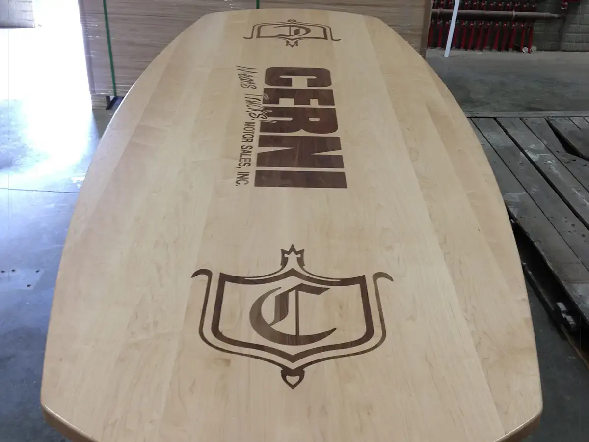 Wood conference table inlaid with the Cerni Motor Sales logo