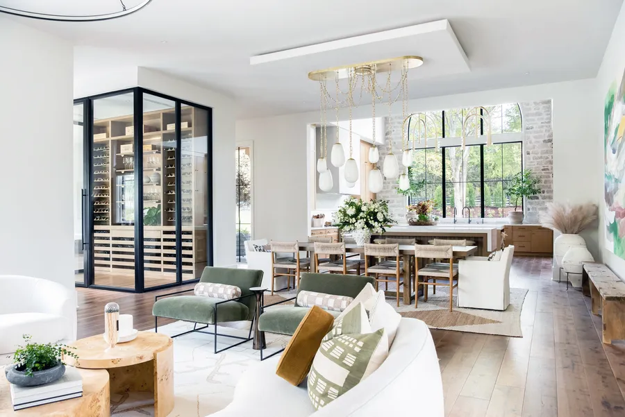 Open living and dining area with a glass-walled wine room and kitchen beyond