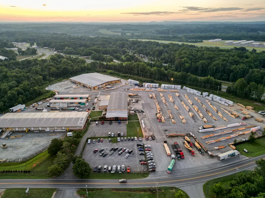Aerial view of a large lumber yard and warehouses at sunset