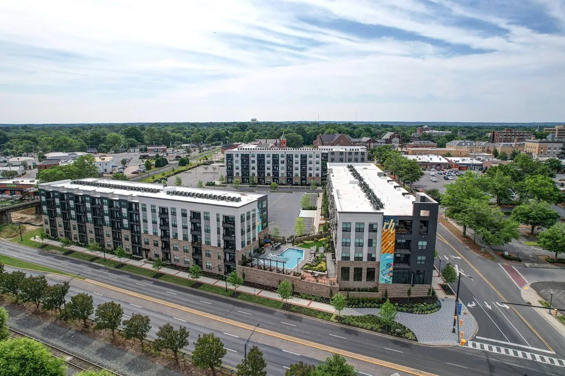Aerial view of modern multi-family apartment buildings with a courtyard pool